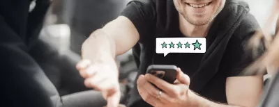 Ein Mann hält ein Smartphone in der Hand und gibt eine 5-Sterne-Bewertung ab, während er jemandem die Hand schüttelt – eine Situation, die die Werbeagentur BICEPS mit BICEPS Reviews für Unternehmen automatisiert.