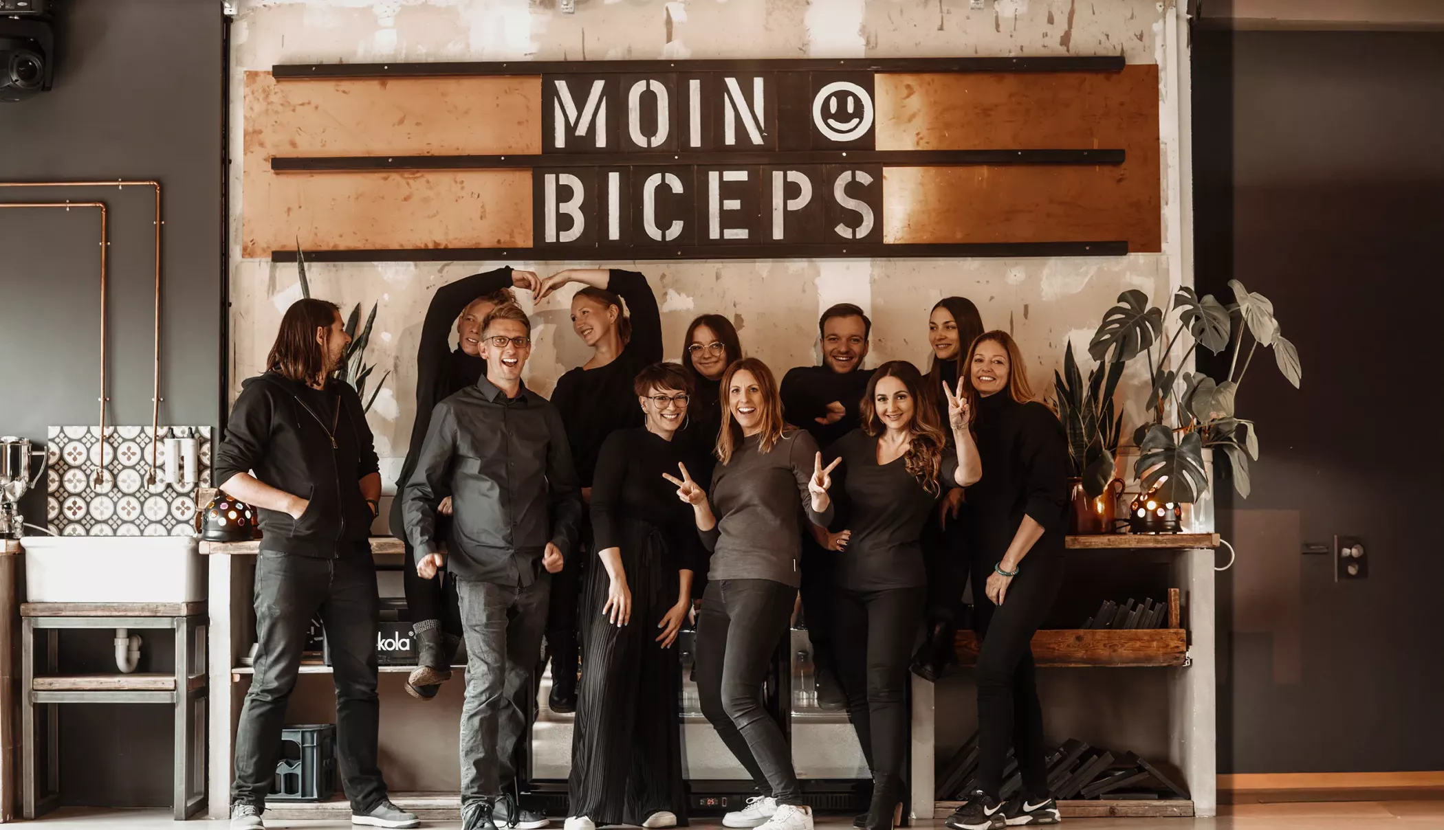 Teamfoto der Werbeagentur BICEPS aus Braunschweig mit Mitarbeitenden aus den Bereichen Branding, Webdesign, SEO, GEO und Online-Marketing in kreativer Agenturatmosphäre.