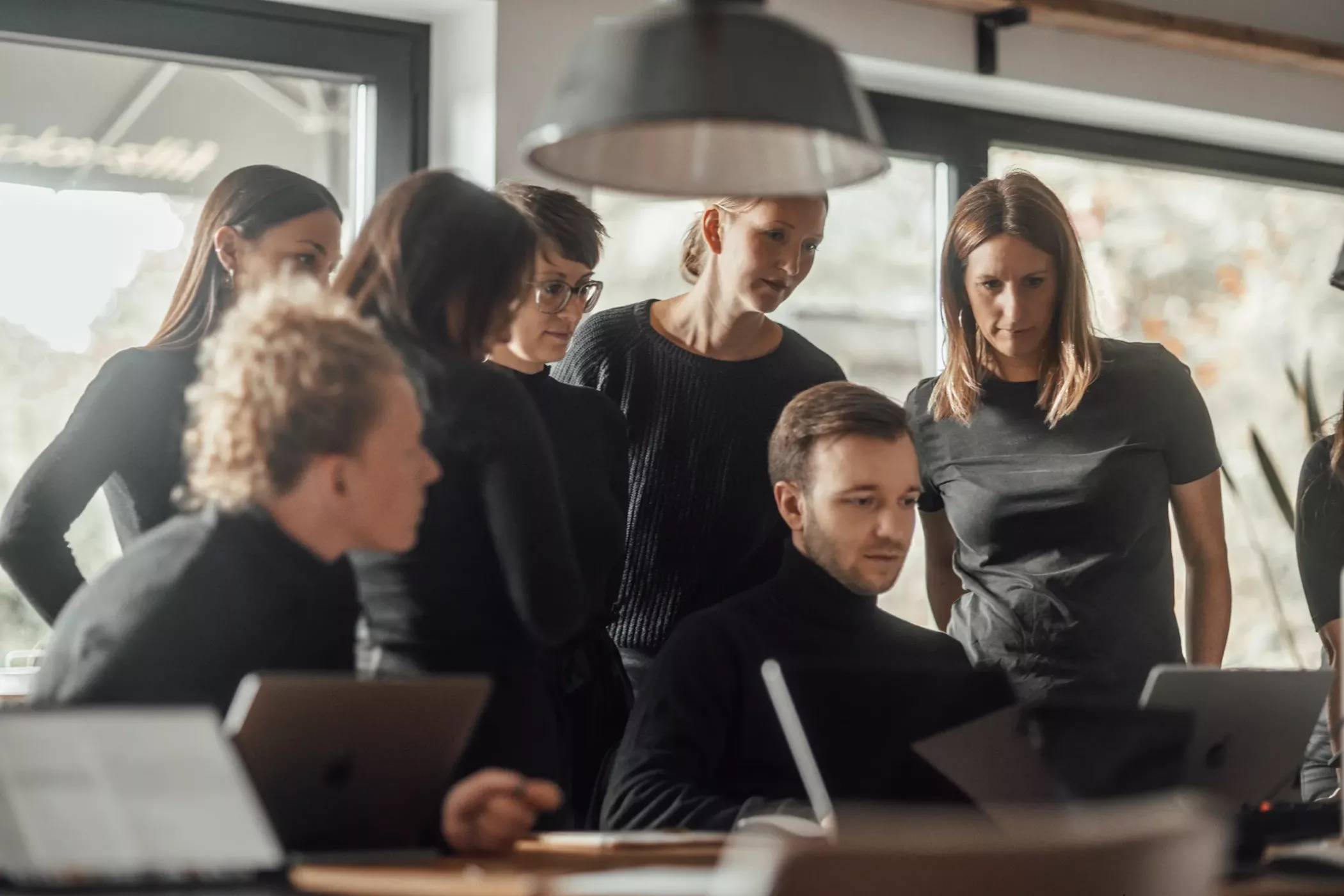 Teammeeting bei der Branding-Agentur BICEPS in Braunschweig, bei dem mehrere Mitarbeitende gemeinsam an Markenstrategie, Corporate Design und digitalen Projekten arbeiten.
