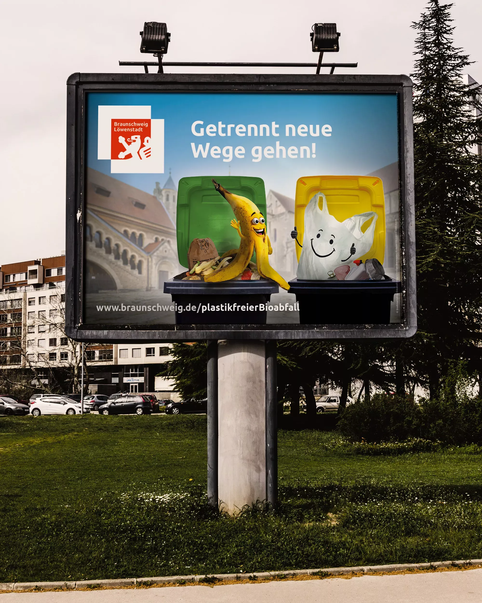 Großflächenplakat der Biomüll-Kampagne im städtischen Raum. Zu sehen sind eine lachende Bananenschale und eine Plastiktüte vor grüner und gelber Tonne mit dem Slogan „Getrennt neue Wege gehen!“.