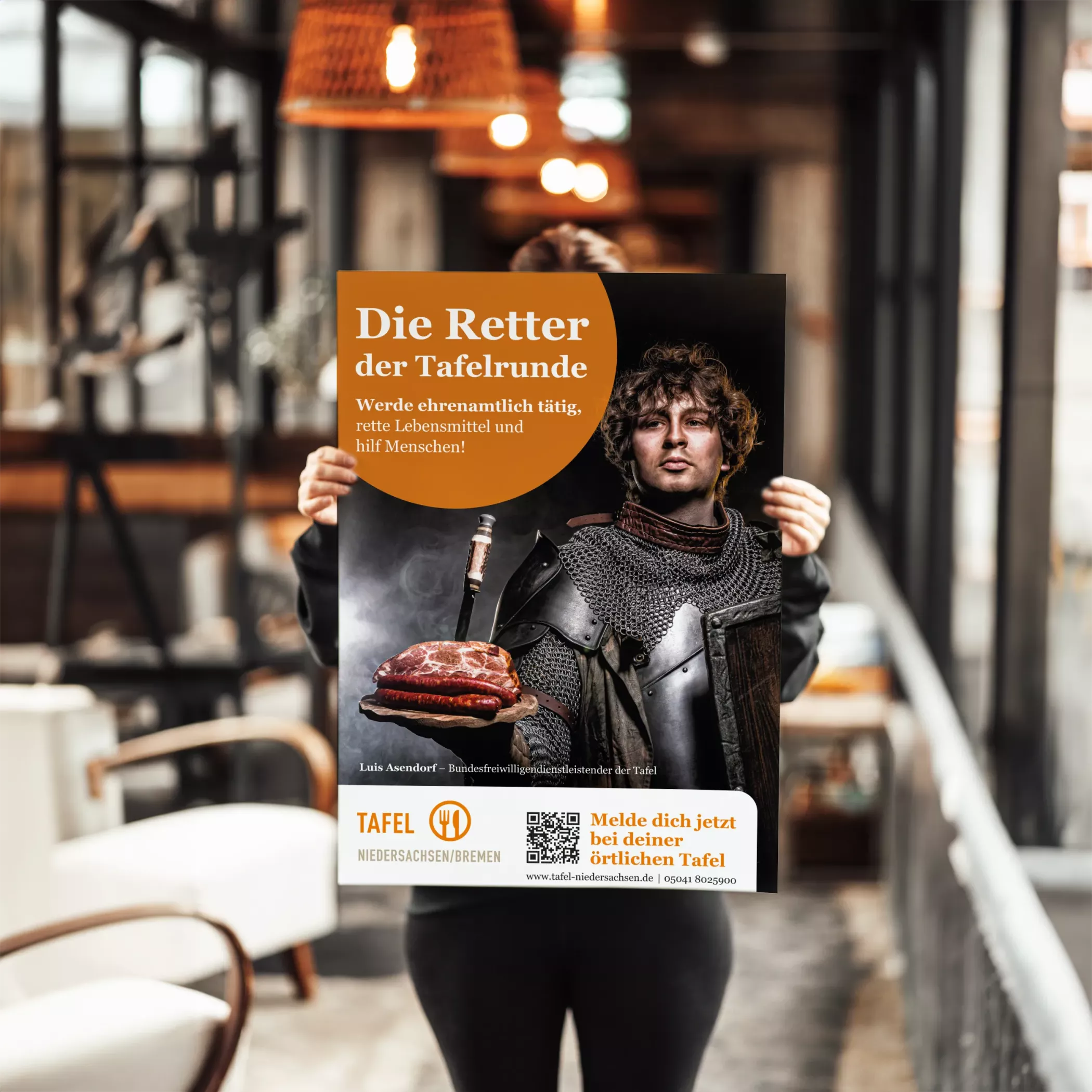 Eine Person hält ein Plakat der Kampagne der