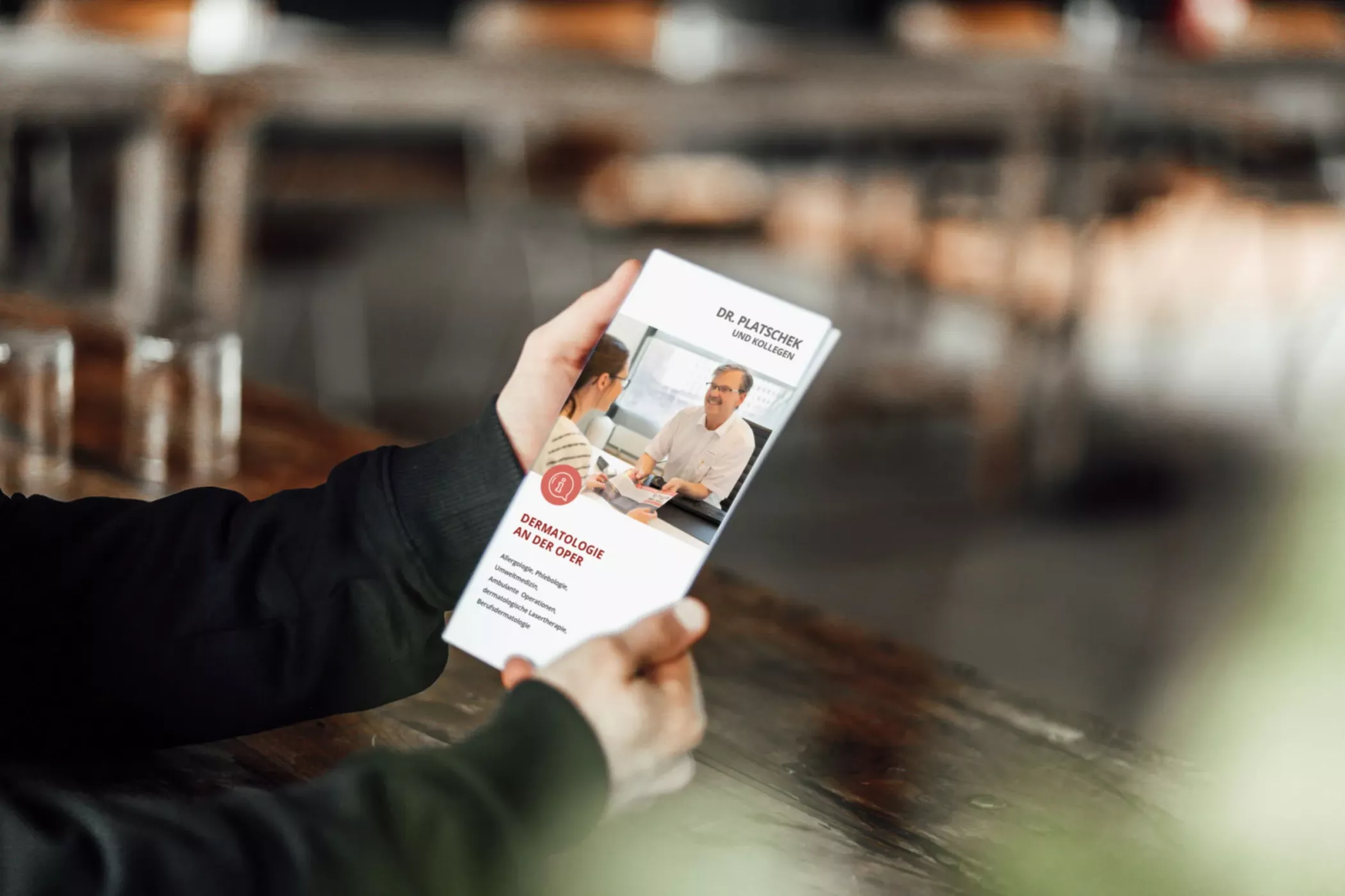 Eine Person hält einen Flyer der 