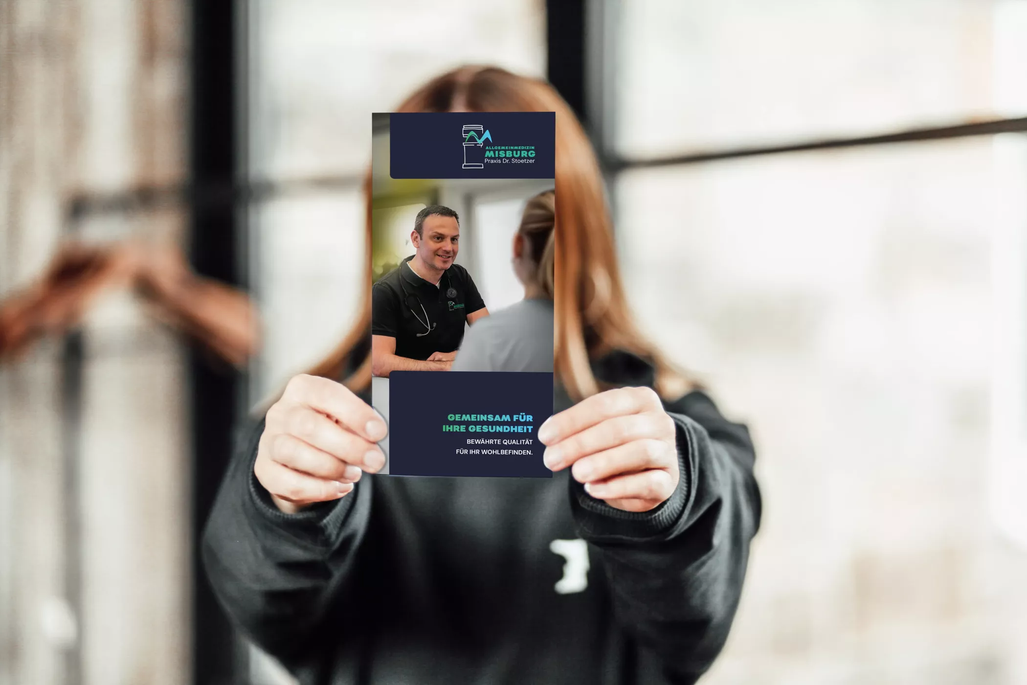 Eine Person hält ein Faltblatt der 