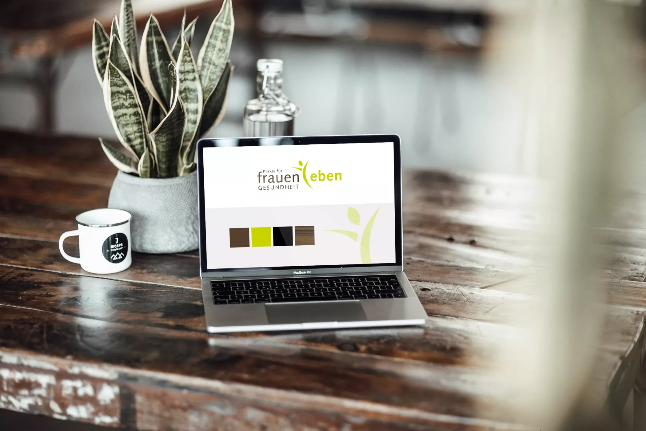 Ein Laptop auf einem Tisch zeigt die Farben der Frauenarztpraxis frauenleben, die im Corporate Design verwendet werden.