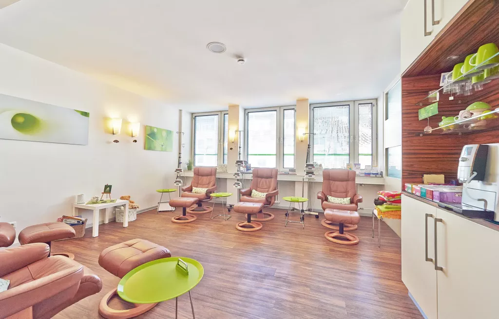 In einem Wartezimmer stehen verschiedene bequeme Stühle.