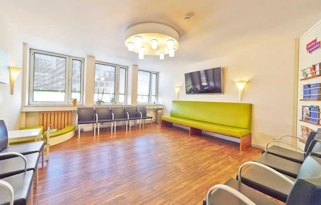In einem Wartezimmer bieten verschiedene Stühle Platz für Patientinnen.
