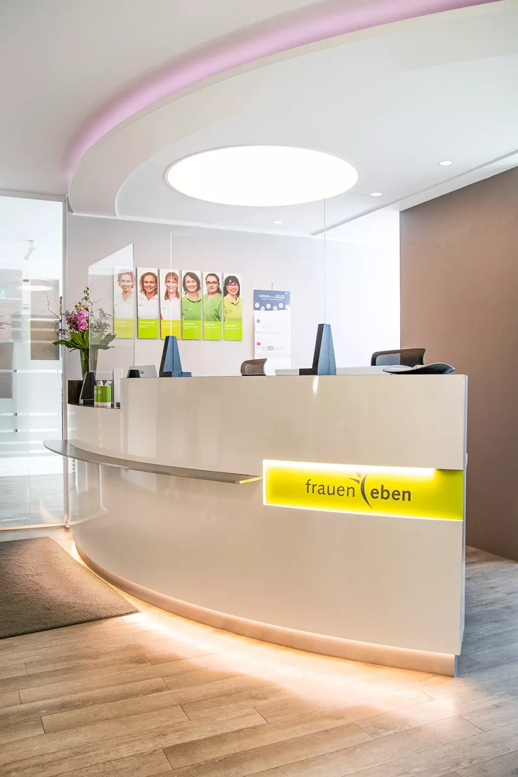 Am Empfangstresen der Frauenarztpraxis hängen Fotos der Mitarbeitenden.