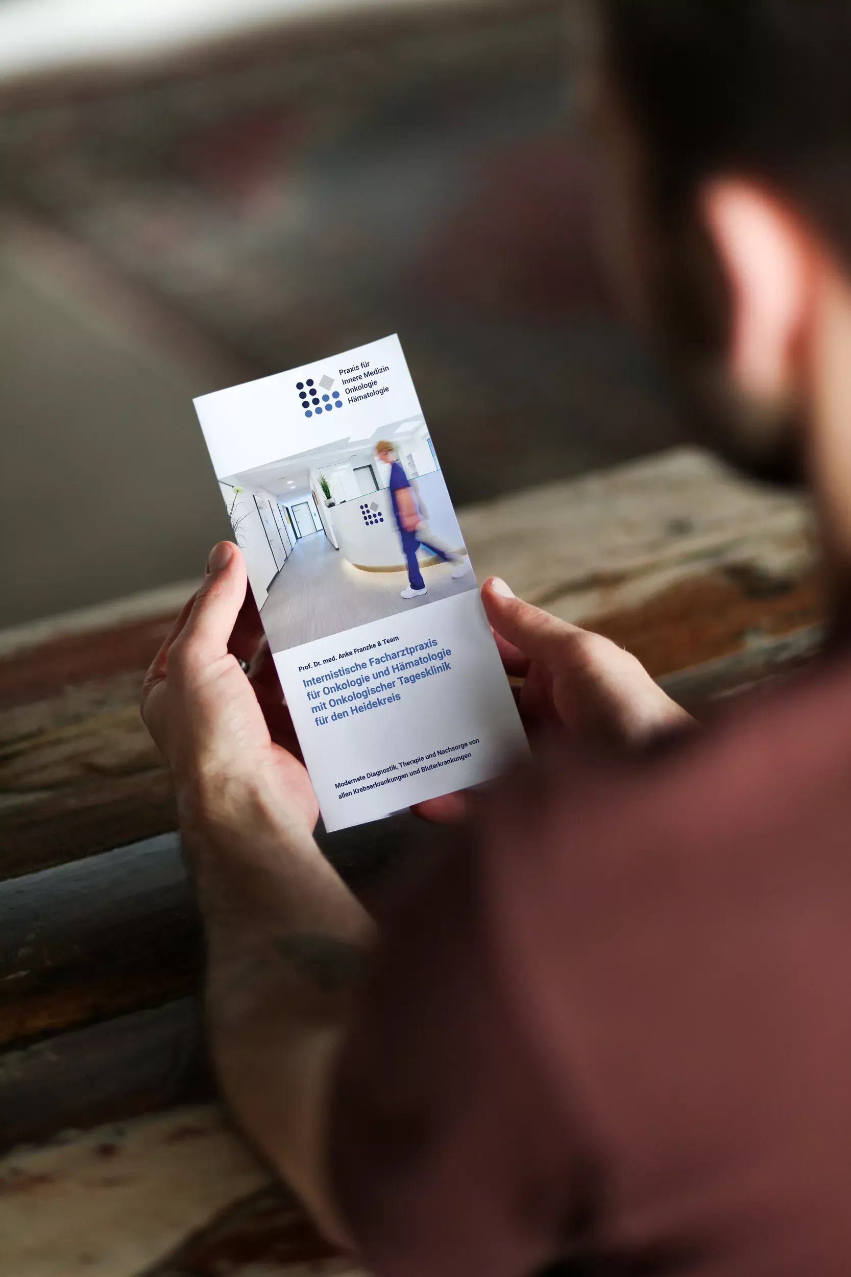 Eine Person hält ein Faltblatt der 