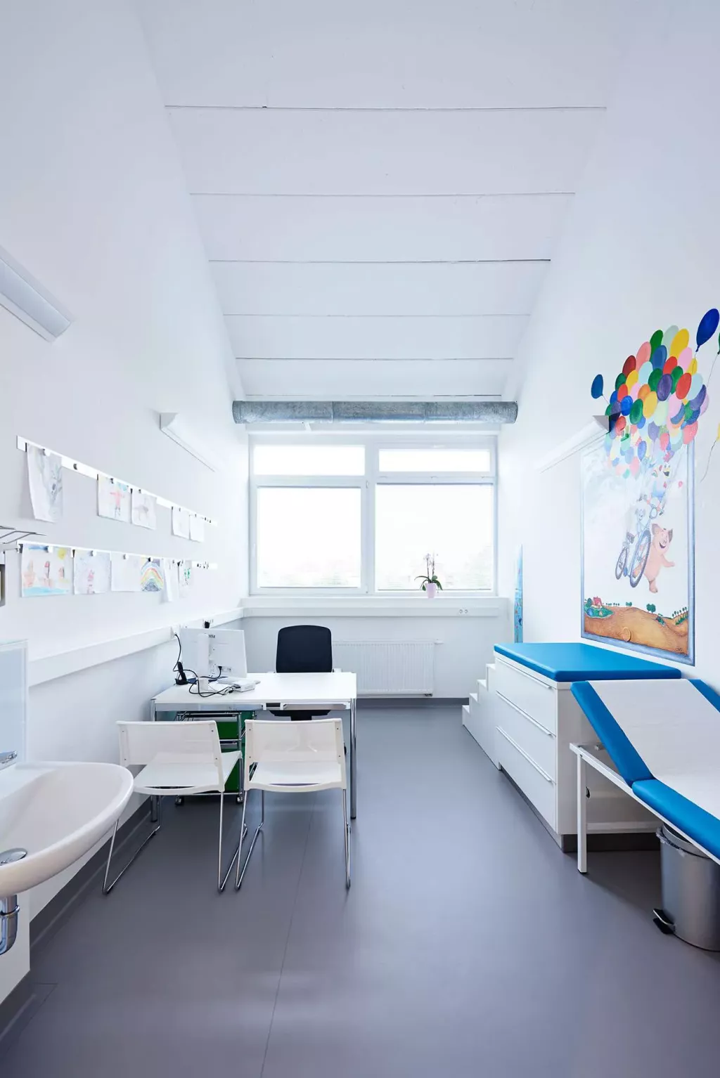 In einem Behandlungszimmer steht eine Liege und ein Tisch mit Stühlen für ein Behandlungsgespräch.