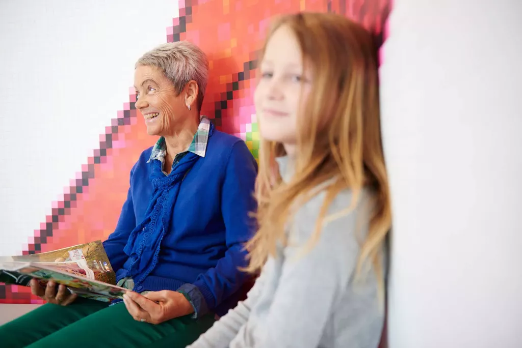 Ein Kind sitzt mit einer Angehörigen im Wartezimmer.