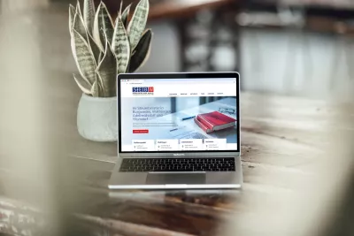 Laptop auf einem Holztisch, auf dem die Website der SEBW Steuerberater mit Startseite und Leistungsübersicht geöffnet ist.