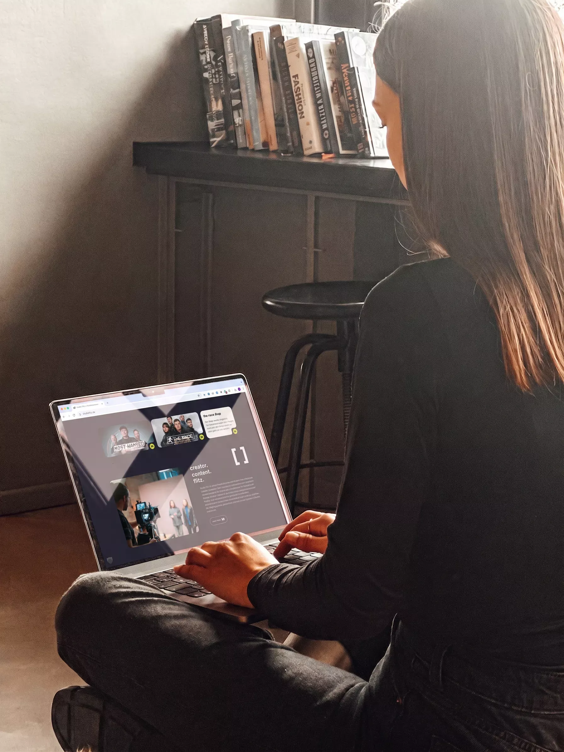 Eine Person hält ein MacBook mit der studio flitz-Website, die die Werbeagentur BICEPS für die Produktionsfirma aus Köln mit WordPress als CMS entwickelt hat.